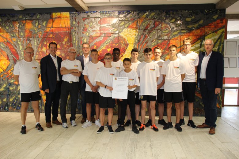 Bürgermeister Thomas Przybylla und Stadtbürgermeister Gerd Harner gratulieren im Beisein von Schulleiter Gerhard Müller der erfolgreichen Jungenmannschaft und ihrem Trainerteam zu ihren Erfolgen.
