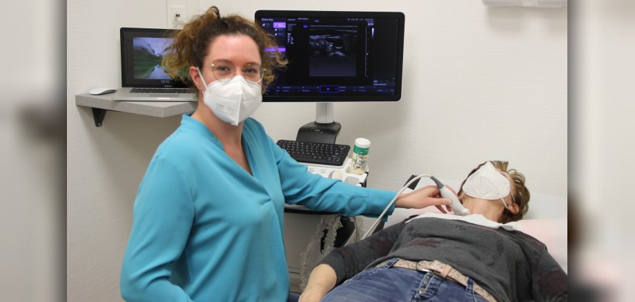 Dr. Klinghuber führt an einem Patienten, der auf der Liege liegt, eine Ultraschall-Untersuchung durch. 