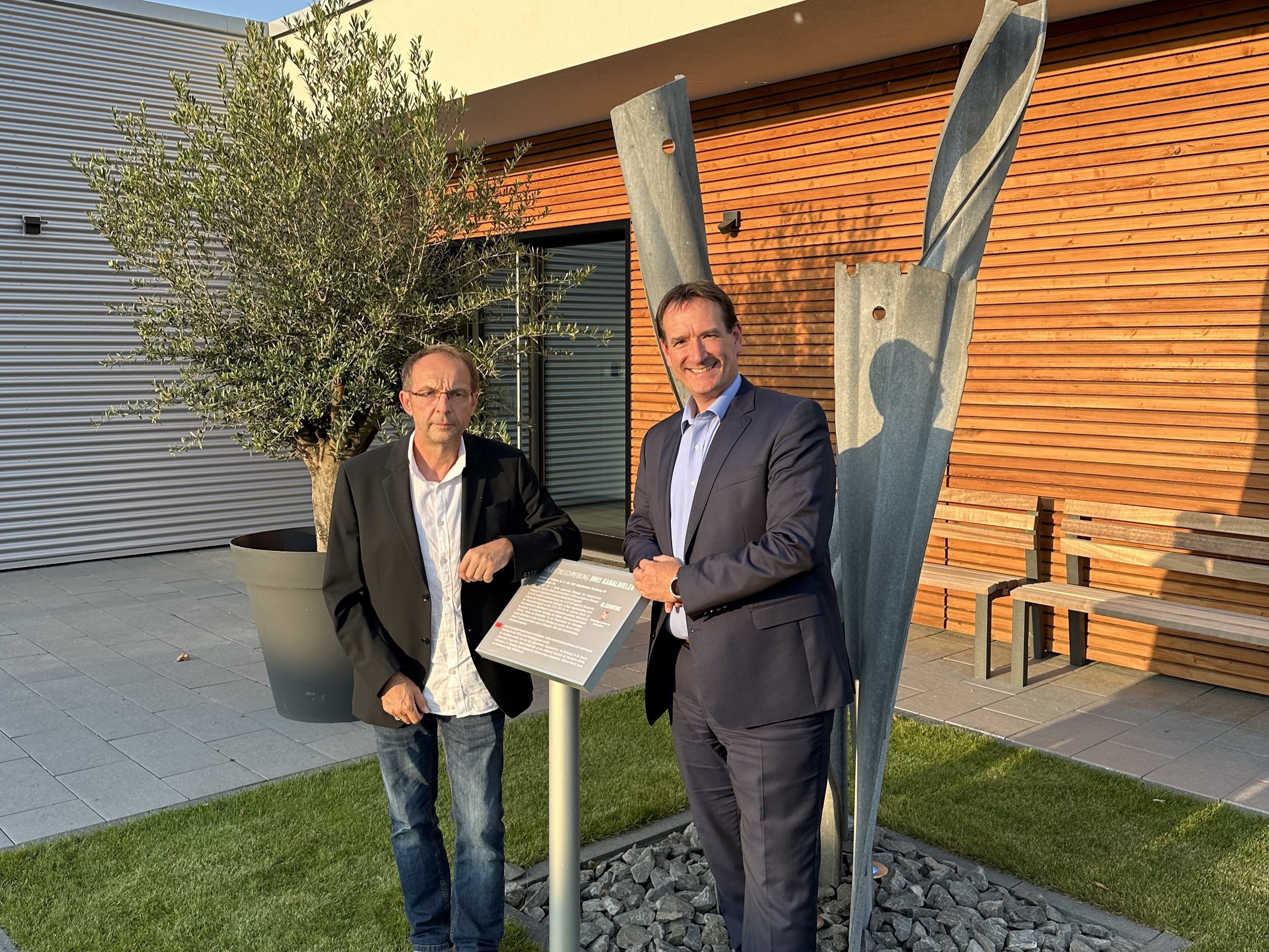 Bürgermeister Thomas Przybylla und Werksleiter Marcus Roth stehen vor dem neuen Betriebsgebäude der Kläranlage. 