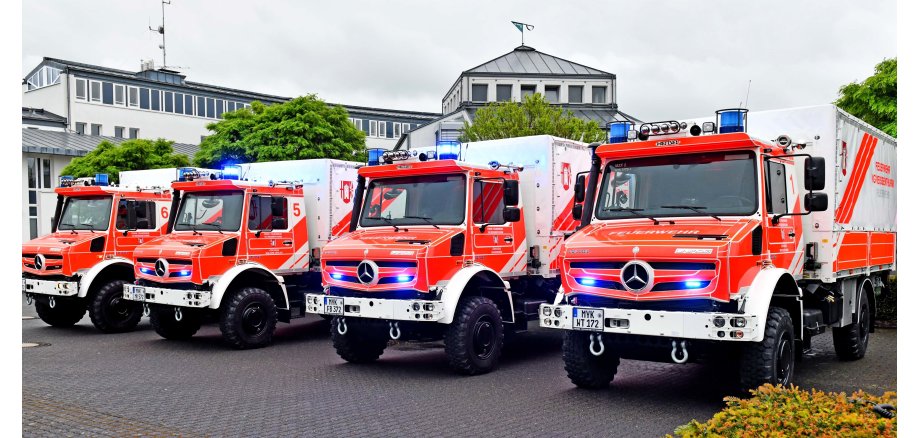 Vor dem Rathaus der Verbandsgemeinde Weißenthurm stehen vier neue Mehrzweckfahrzeuge, deren Blaulichter angeschaltet sind.