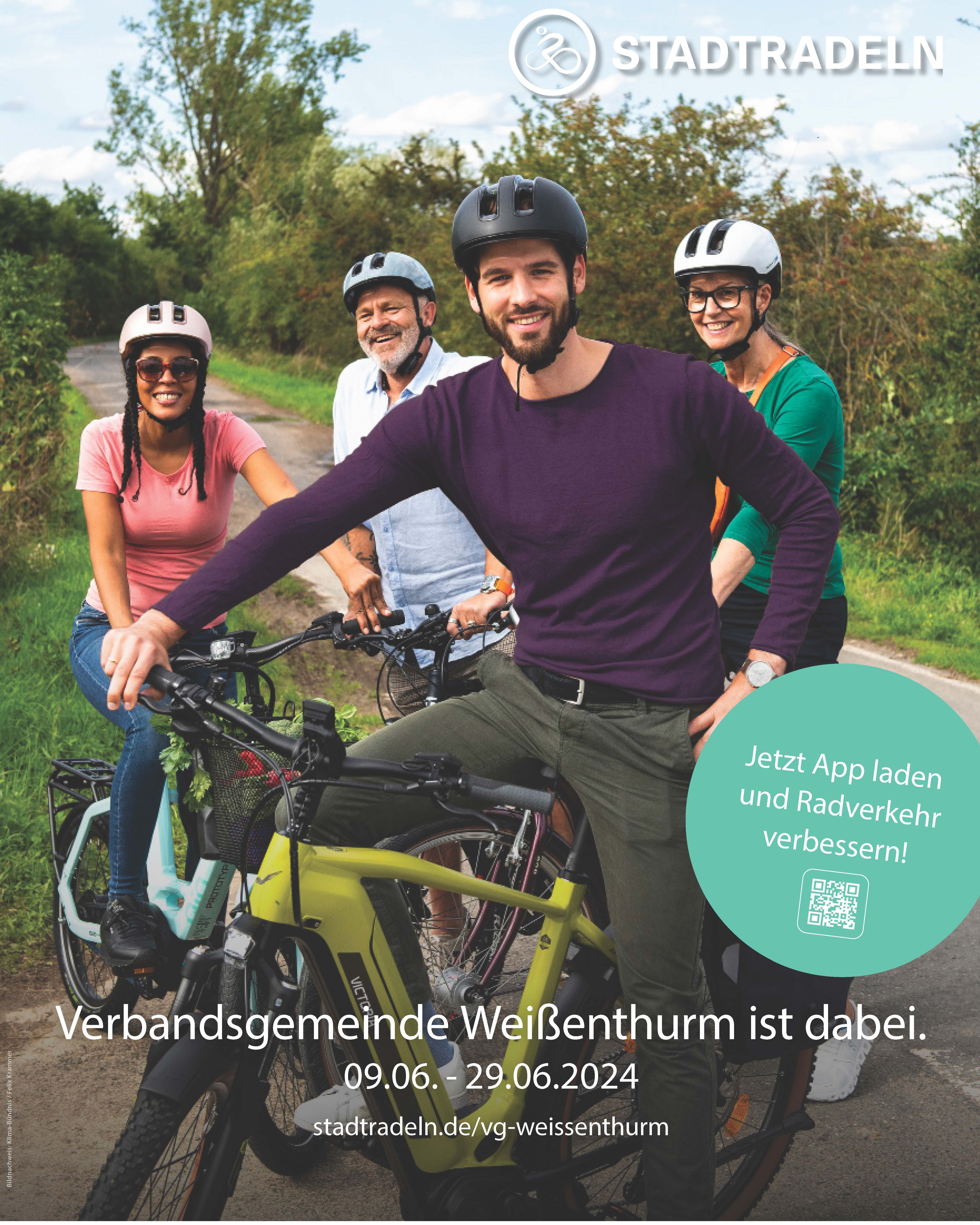 Vier junge Menschen sitzen im Grünen auf Fahrrädern. Alle tragen Fahrradhelme. Ein junger Mann ist im Vordergrund quer im Bild, die anderen drei hinter ihm.
