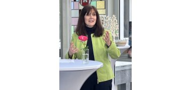 Die Gleichstellungsbeauftragte des Landkreises Mayen-Koblenz, Lea Bales, spricht an einem Stehtisch und gestikuliert mit beiden Händen