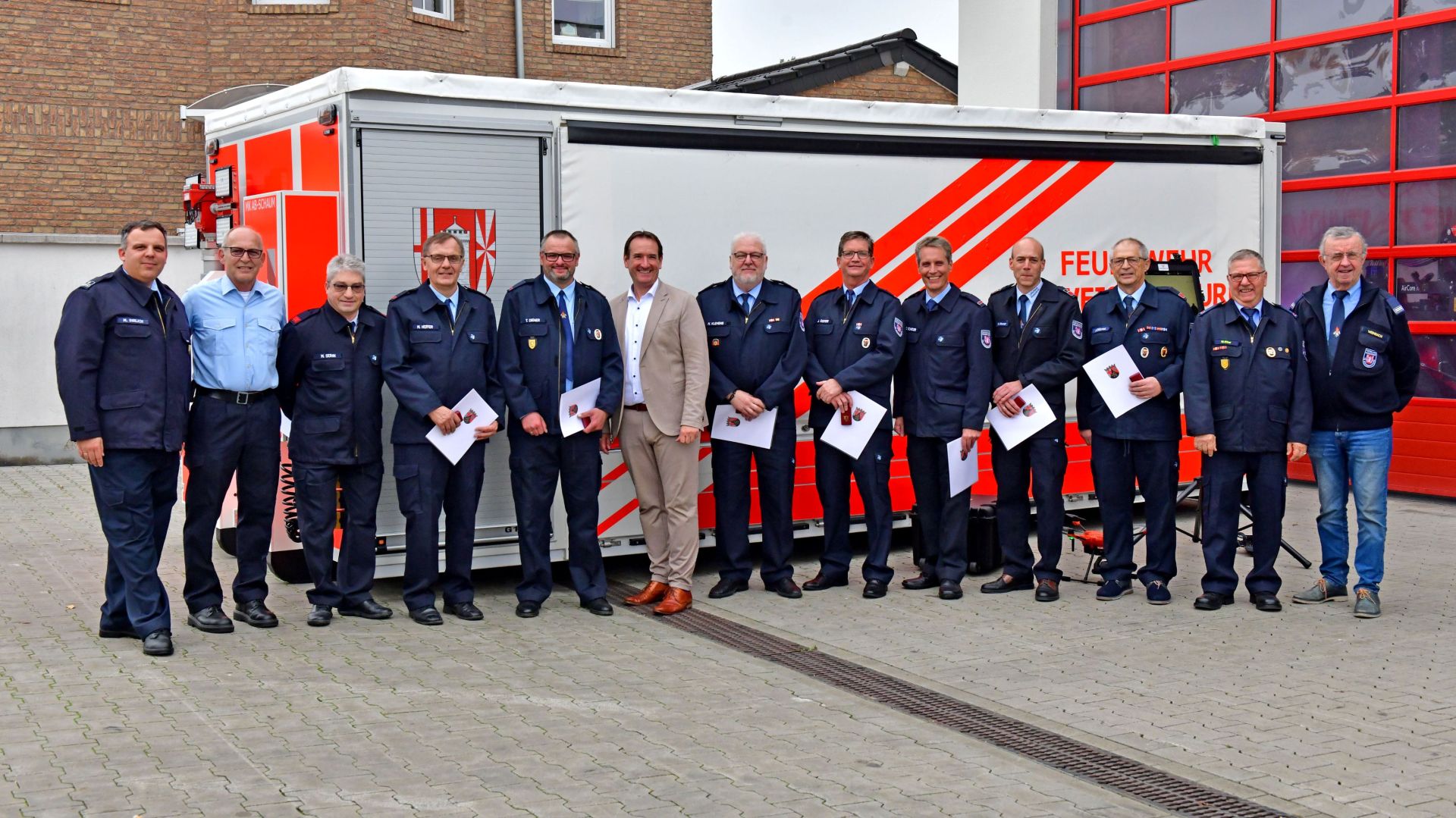 Alters- und Ehrenabteilung Feuerwehr Ehrungen Vor dem Feuerwehrgerätehaus und einem Löschfahrzeug stehen alle Geehrten mit Bürgermeister Thomas Przybylla und Wehrleiter Arnd Lenarz.