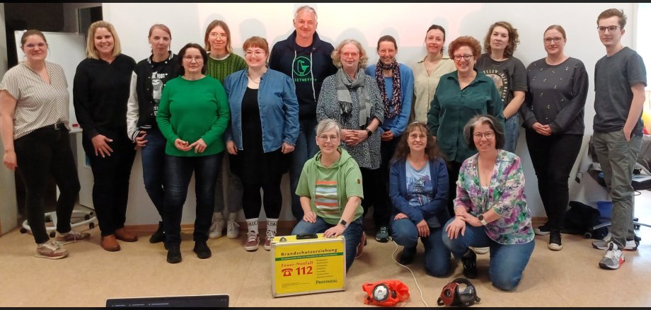 Die beteiligten Erzieherinnen der Kita St. Martin in Bassenheim stehen mit Dozentin Annika Wolff hinter einigen Brandschutzutensilien. 