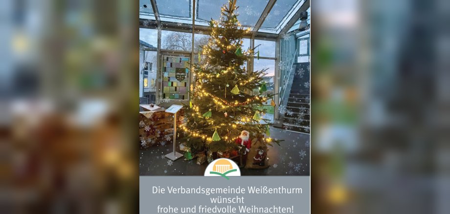 Der geschmückte Weihnachtsbaum im Foyer des Rathauses ist von Schneeflocken umgeben. 