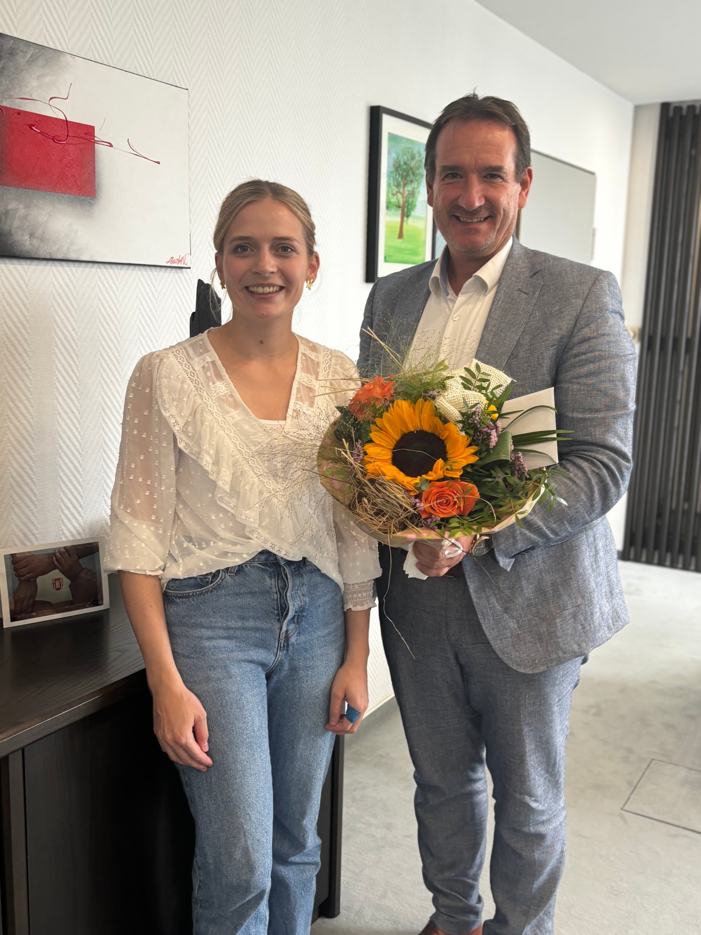 Bürgermeister Thomas Przybylla überreicht Rowena Redwanz einen bunten Blumenstrauß.