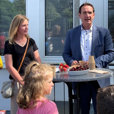 Die stellvertretende Schulleiterin Christina Zimmermann und Bürgermeister Thomas Przybylla stehen an einem Stehtisch, davor eine Schülerin. 