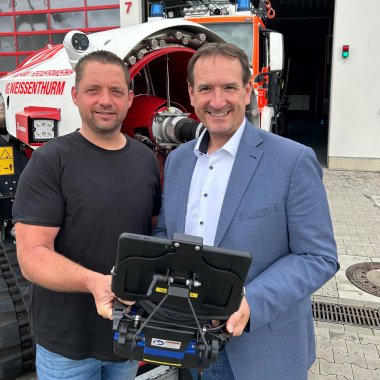 Löschroboter Bürgermeister mit Wehrführer Bürgermeister Thomas Przybylla steht mit Wehrführer Torsten Schnack vor dem Löschroboter mit der Tablet-Fernsteuerung in der Hand.
