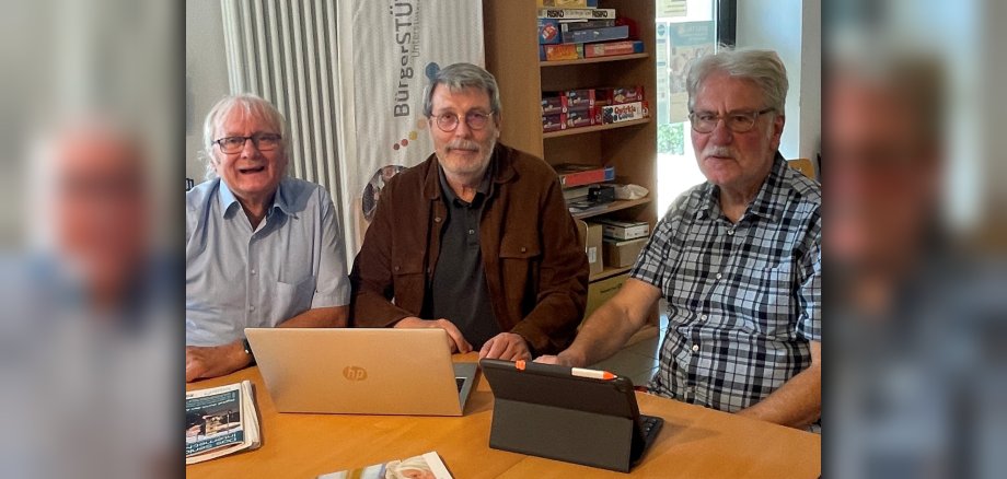 Die drei Digitalbotschafter Josef Gilles, Ingo Neumann und Karl-Heinz Krambeer (von links) sitzen vor einem aufgeklappten Laptop am Tisch.