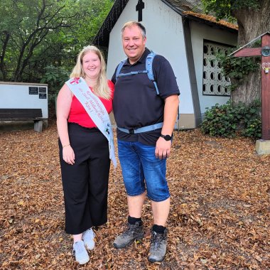 Obstwanderung Kirschblütenkönigin Gärtnermeister Andreas Anheier und Kirschblütenkönigin Kira I. stehen an einer Grillhütte während der Obstwanderung.