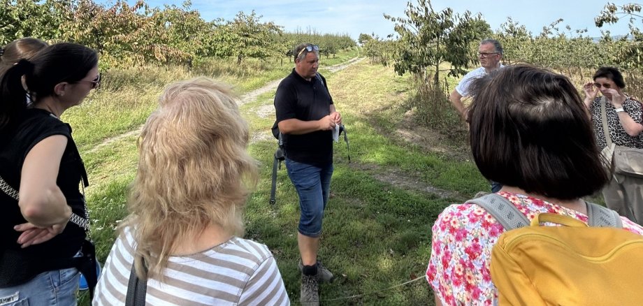 Gärtnermeister Andreas Anheier gibt Informationen an die Gruppe, die an der Ostwanderung teilnimmt.