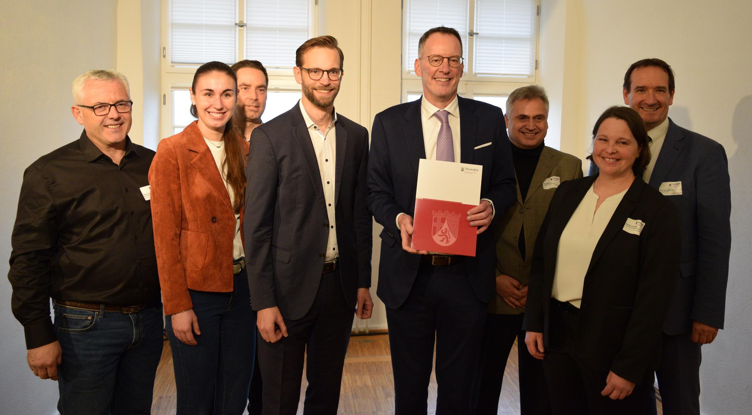 Um Innenminister Michael Ebling stehen Vertreterinnen und Vertreter der Kommunen, die an dem Projekt Prozessoptimierung beteiligt sind.