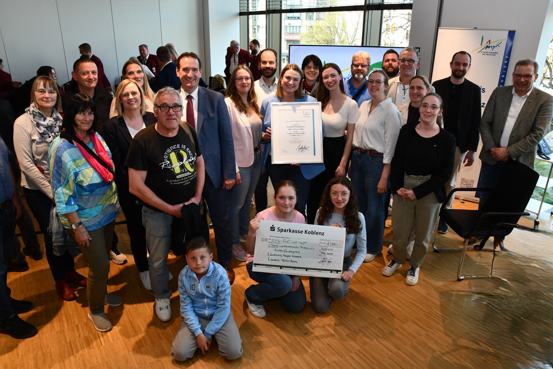 Mit VG-Bürgermeister Thomas Przybylla, dem Mülheim-Kärlicher Stadtbürgermeister Gerd Harner und der Ersten Beigeordneten Martina Böth-Baulig sind die Fidelio-Mitglieder mit Urkunde und Scheck zu sehen.