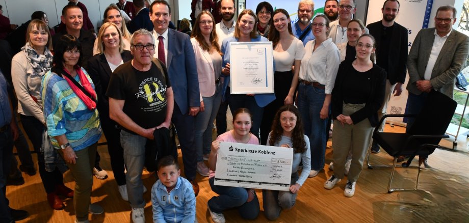 Mit VG-Bürgermeister Thomas Przybylla, dem Mülheim-Kärlicher Stadtbürgermeister Gerd Harner und der Ersten Beigeordneten Martina Böth-Baulig sind die Fidelio-Mitglieder mit Urkunde und Scheck zu sehen.