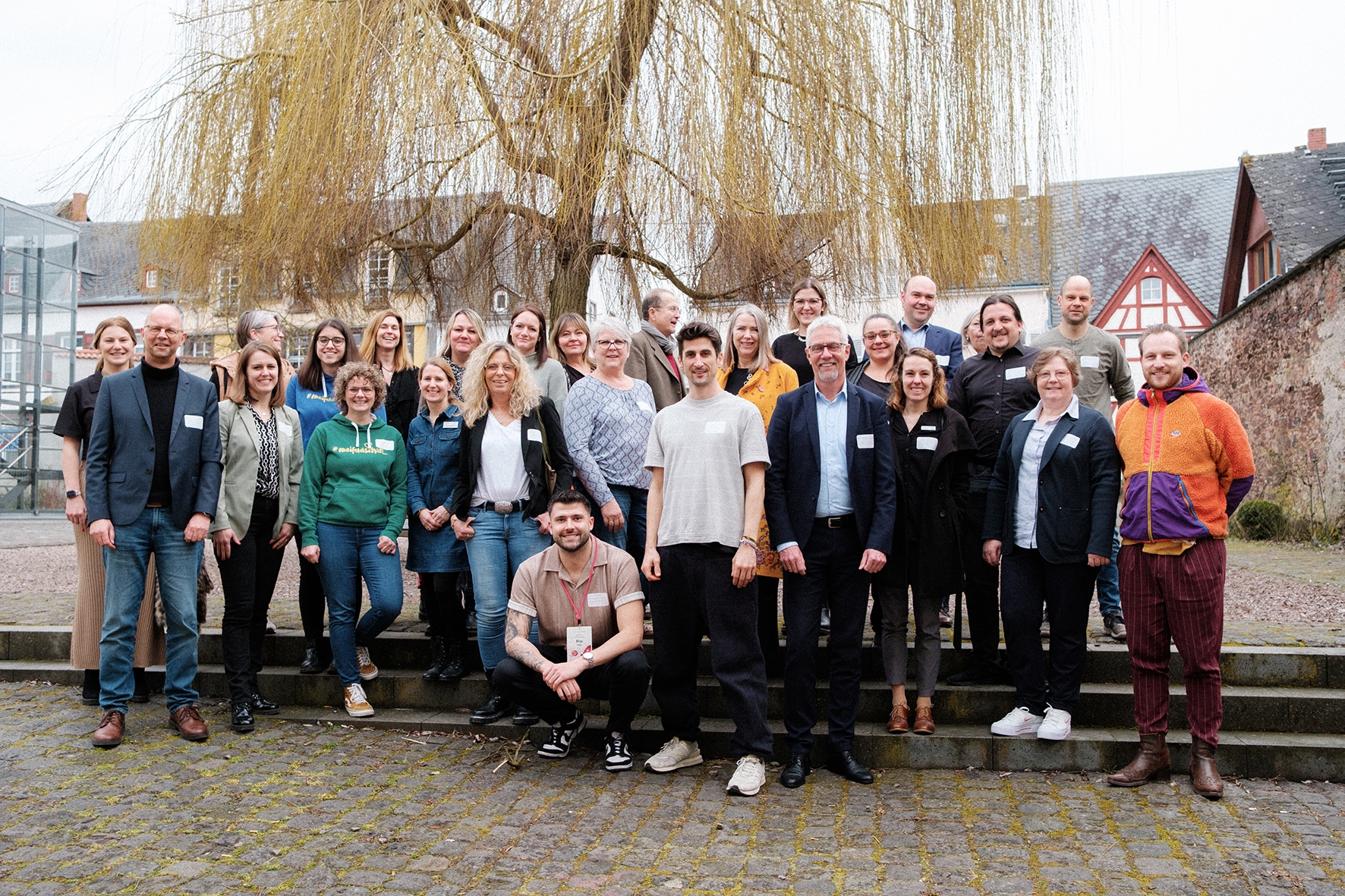 Die Teilnehmerinnen und Teilnehmer am Workshop zum Projekt Zeitreise stehen vor einem Baum. 