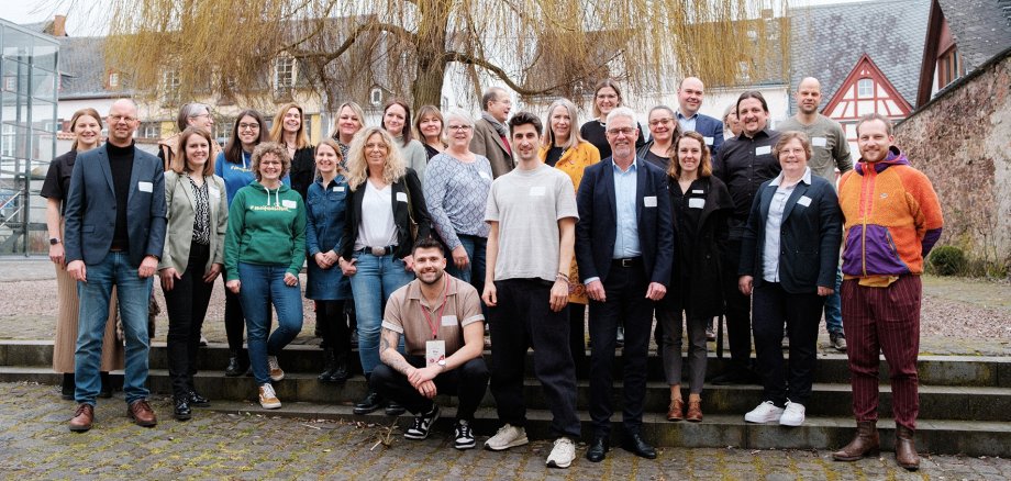 Die Teilnehmerinnen und Teilnehmer am Workshop zum Projekt Zeitreise stehen vor einem Baum. 