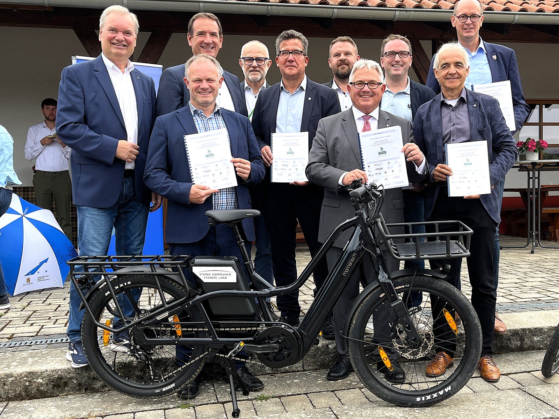 Vertreter der beteiligten Kommunen an der geplanten Pendlerradroute stehen vor dem Rathaus der VG Rheinbrohl. 