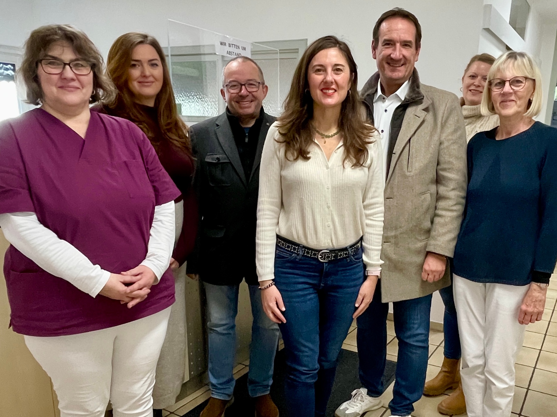Bürgermeister Thomas Przybylla steht mit dem Weißenthurmer Stadtbürgermeister Johannes Juchem, VG-Mitarbeiterin Kristina Uerz und der Ärztin Sara Tolarechipi mit Team am Empfang der Praxis. 