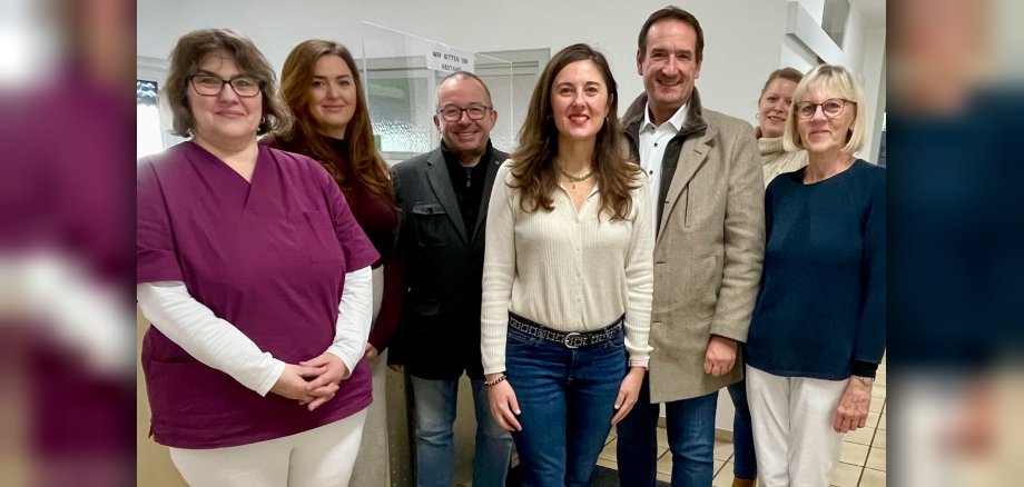 Praxisübernahme Tolarechipi Bürgermeister Thomas Przybylla steht mit dem Weißenthurmer Stadtbürgermeister Johannes Juchem, VG-Mitarbeiterin Kristina Uerz und der Ärztin Sara Tolarechipi mit Team am Empfang der Praxis.