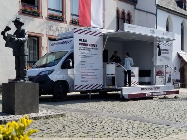 Infomobil Mülheim-Kärlich Das Infomobil steht auf dem Rathausplatz mit der Statue des Ausschellers im Vordergrund.