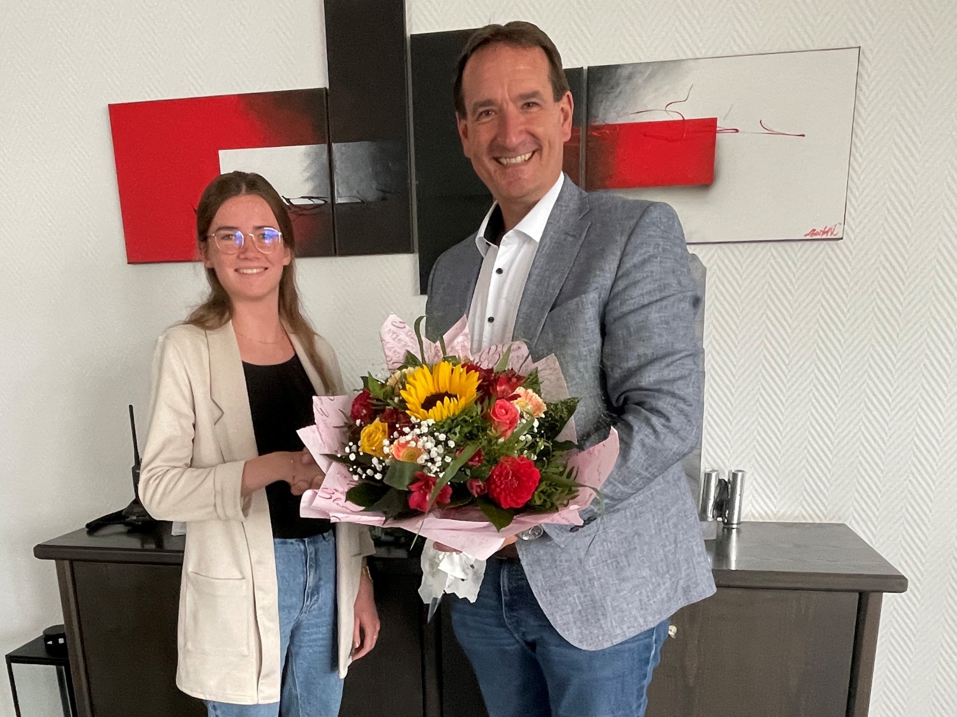 Absolventin Sarah Schiller bekommt von Bürgermeister Thomas Przybylla einen Blumenstrauß überreicht.