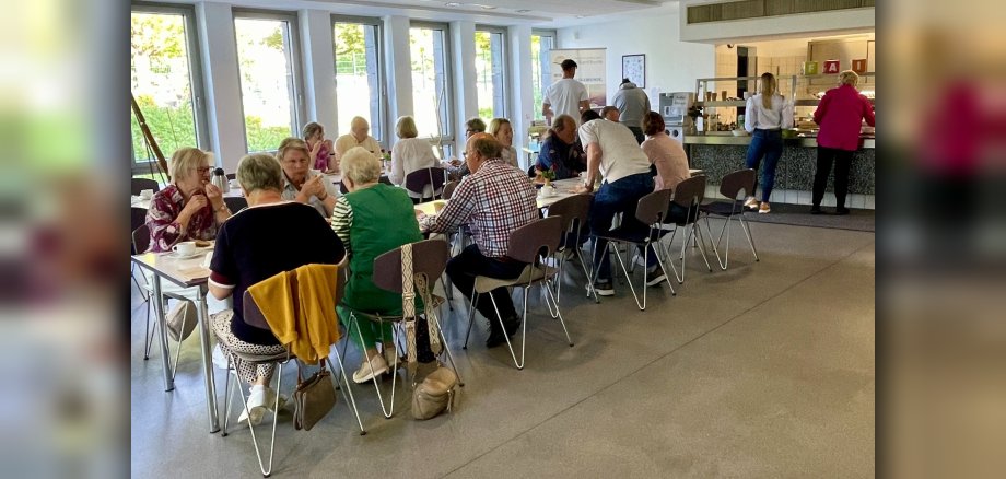 An zwei Tischen in der Kantine des VG-Rathauses sitzen externe und interne Gäste und frühstücken.
