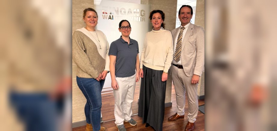 Förderung Weiterbildungsassistenz Bürgermeister Thomas Przybylla und Kristina Uerz von der Wirtschaftsförderung stehen mit der Ärztin Anja Klinghuber und der Weiterbildungsassistentin Daniela Schrader in der Bassenheimer Hausarztpraxis.