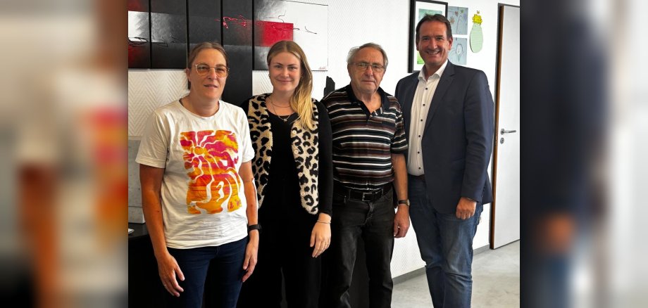 Bürgermeister Thomas Przybylla und Wirtschaftsförderin Kim Lachmann stehen mit Kurt Schüller und Heike Kohlhaas vom SV Urmitz im Büro des Bürgermeisters. 