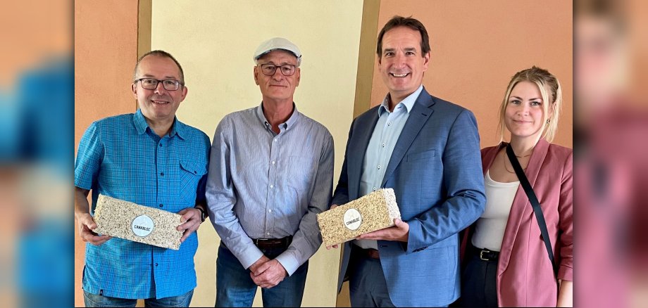 VG-Bürgermeister Thomas Przybylla, Wirtschaftsförderin Kim Lachmann und der Weißenthurmer Stadtbürgeremister Johannes Juchem zeigen mit Joachim Schlauß von NICK Naturbaustoffe den Hanfkalkstein Canabloc.