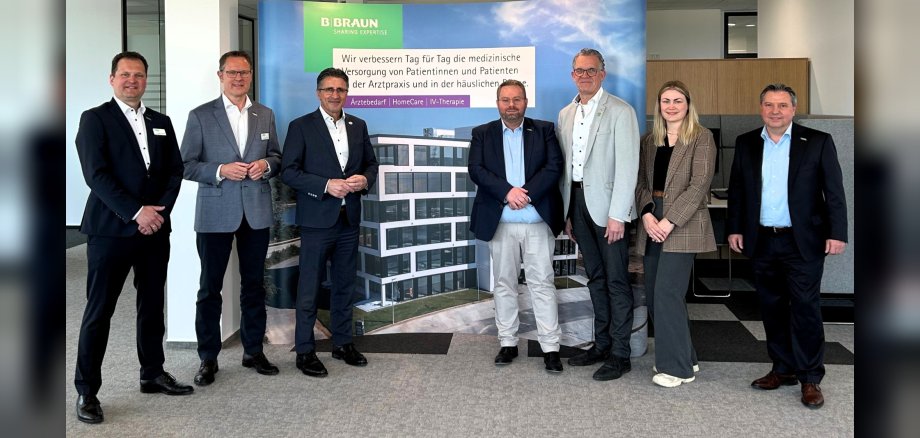 Wirtschaftsförderin Kim Lachmann steht mit dem Mülheim-Kärlicher Stadtbürgermeister Gerd Harner, Investor Ilmi Viqa und Vertretern der Firm B. Braun im Foyer des Unternehmens.