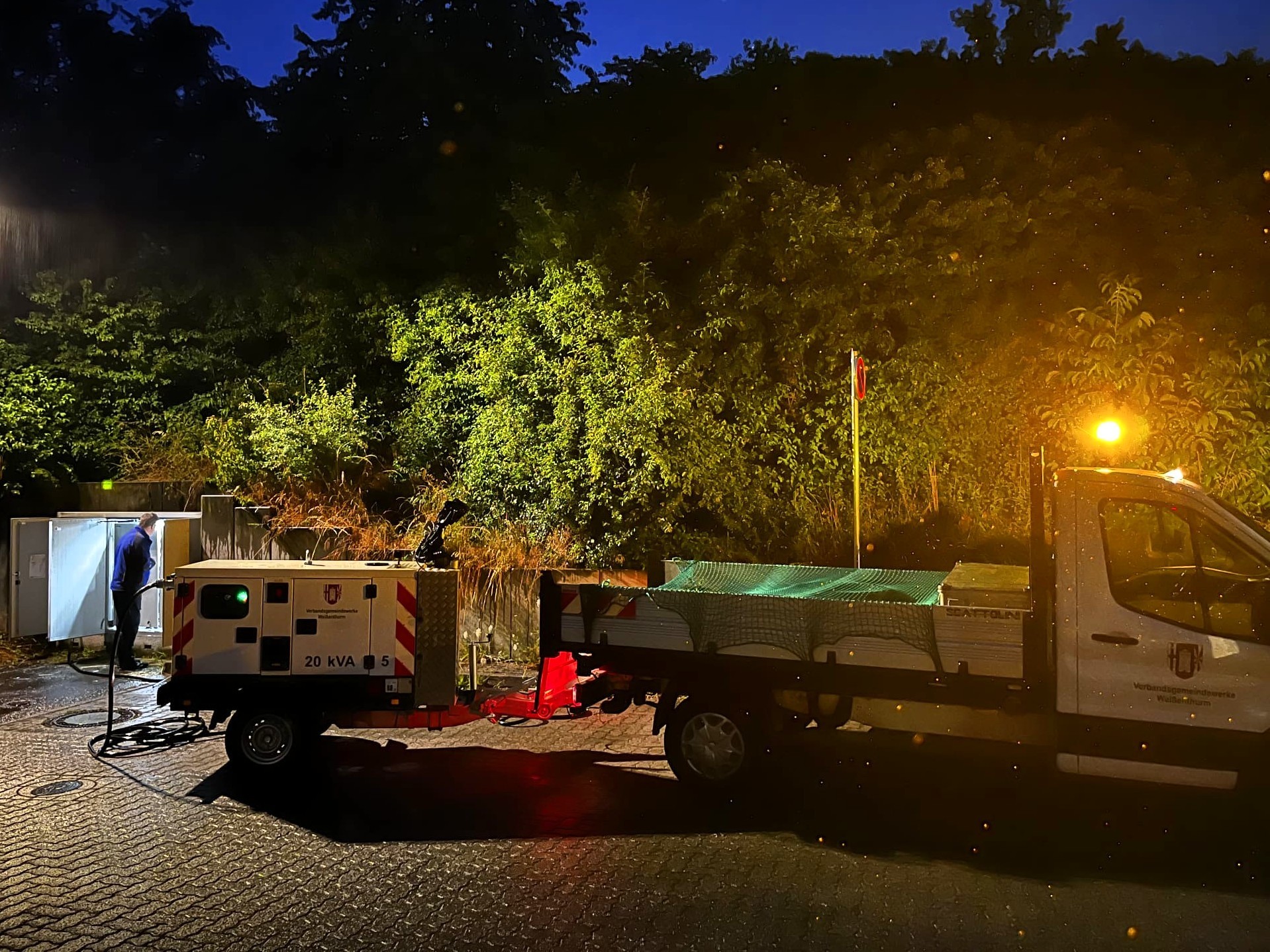 Übung Werke Foto Notstromaggregat nachts Ein Fahrzeug der VG Weißenthurm mit einem angehängten Notstromaggregat und einem Scheinwerfer auf dem Dach steht in der Dunkelheit an einem Schaltkasten.