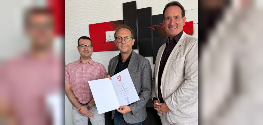 Dienstjubiläum Markus Roth Foto Werkleiter Markus Roth steht mit der Urkunde zum 25jährigen Dienstjubiläum zwischen Bürgermeister Thomas Przybylla und dem Vertreter des Personalrats, Christian Volk.