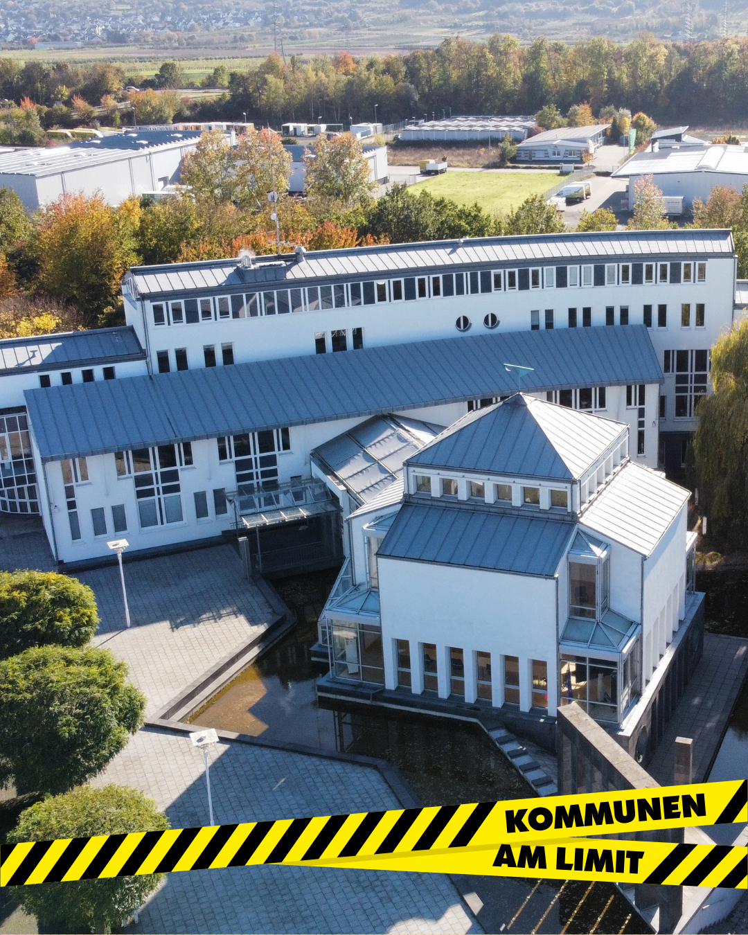 Aktionstag Kommunen am Limit Grafik Am unteren Bildrand ist über dem Rathaus der VG das gelb-schwarze Absperrband des Aktionstags mit dem Schriftzug "Kommunen am Limit" zu sehen.