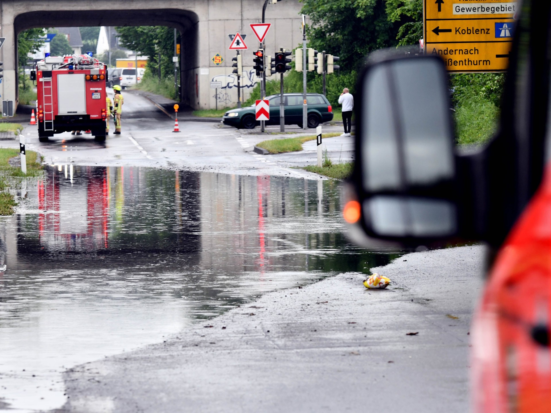 Foto Infoveranstaltung Hochwasserkonzept Eine überflutete Straße wird von Feuerwehrfahrzeugen bewacht.