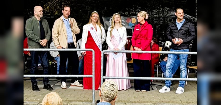 Auf der Bühne begrüßt Bürgermeister Thomas Prybylla gemeinsam mit der Geschäftsführerin der Förder- und Wohnstätte Kettig, Iris Schubert, dem Kettiger Ortsbürgermeister Florian Heyden, seinem Amtsvorgänger und MdL Peter Moskopp und der Mülheim-Kärlicher Kirschblütenkönigin Annemarie I sowie der Kettiger Blütenkönigin Victoria I. die Gäste.