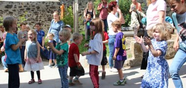 Bewegungskita St. Martin Foto Sommerfest Auf der Terrasse der Kita St. Martin sind Kinder und Gäste des Sommerfestes versammelt.