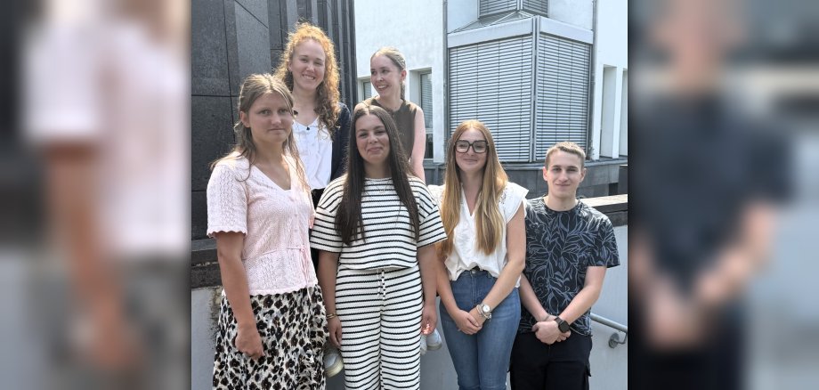 vier neue Azubis stehen mit den Ausbildungsleiterinnen Johanna Püsch und Emily Kisner vor dem Rathaus. 