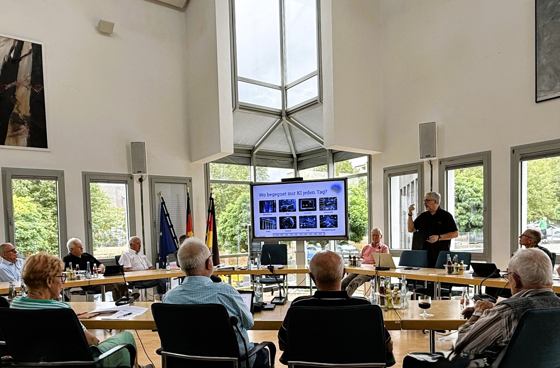 Der Seniorenbeirat tagt im Ratssaal, vorne steht Referent Jörg Eisbach und hält einen Vortrag. 