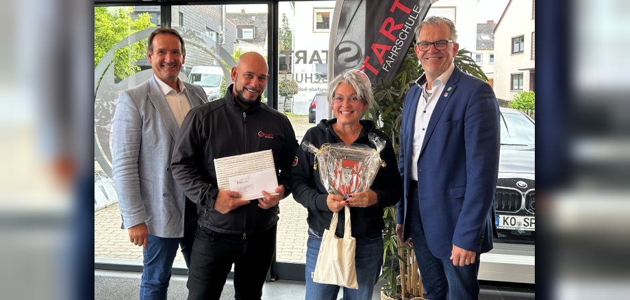 Eröffnung START Fahrschule VG-Bürgermeister Thomas Przybylla und der Mülheim-Kärlicher Stadtbürgermeister Gerd Harner stehen mit Fahrschulinhaberin Alexandra Löhr und einem Fahrlehrer in der neuen Fahrschule.