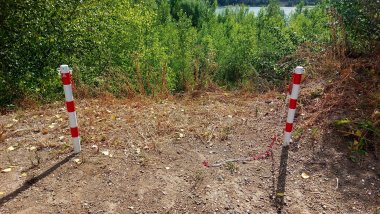Vandalismus Kiesrundweg Foto Pfosten 1 An zwei rot-weißt gestreiften Pfosten hängen jeweils Reste einer rot-weißen Kette.