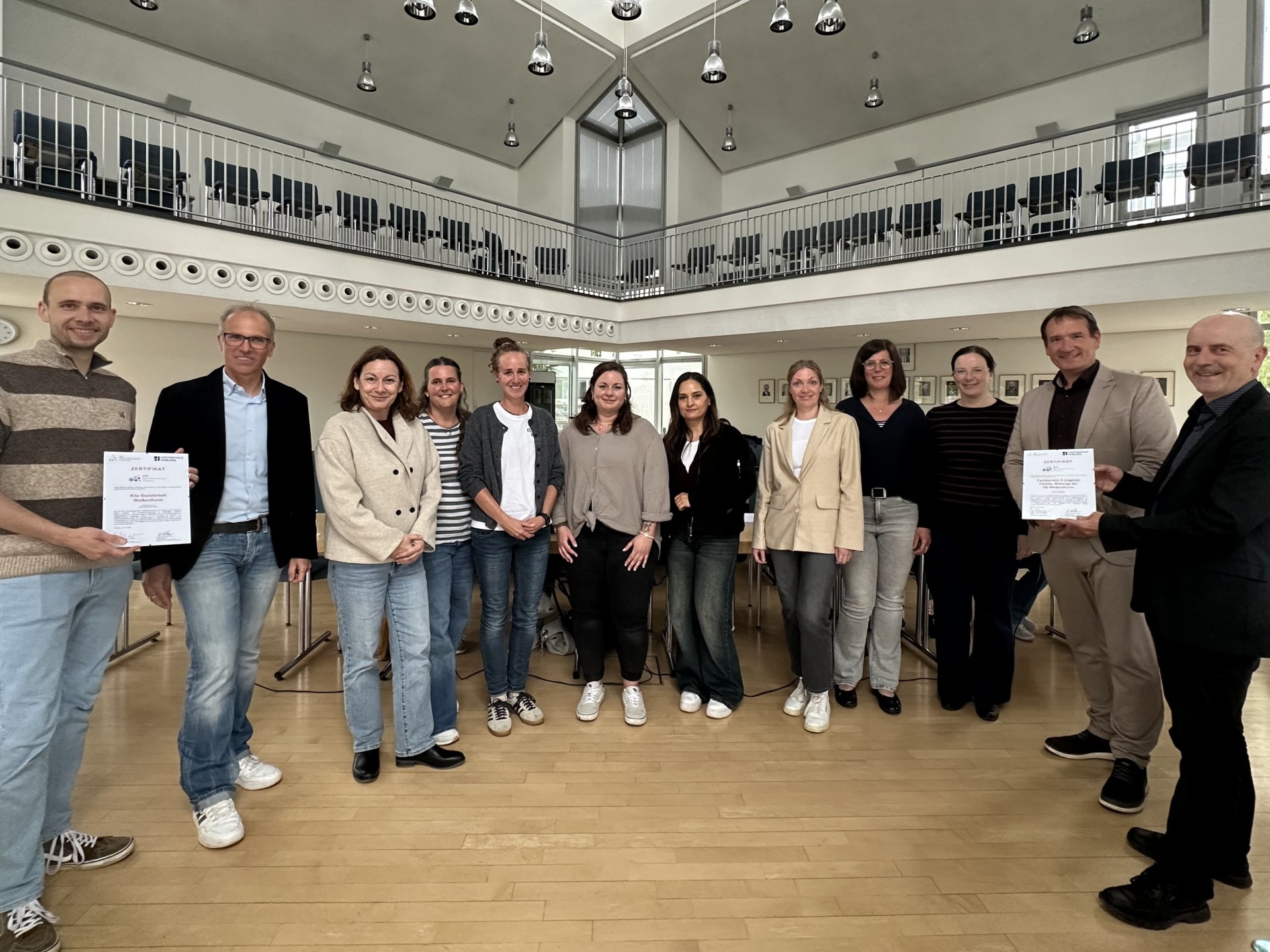 QID-Zertifikat Foto Alle am Prozess Beteiligten stehen mit Bürgermeister Thomas Przybylla und Fachbereichsleiter Sven Normann mit jeweils einer Urkunde im VG-Ratssaal.
