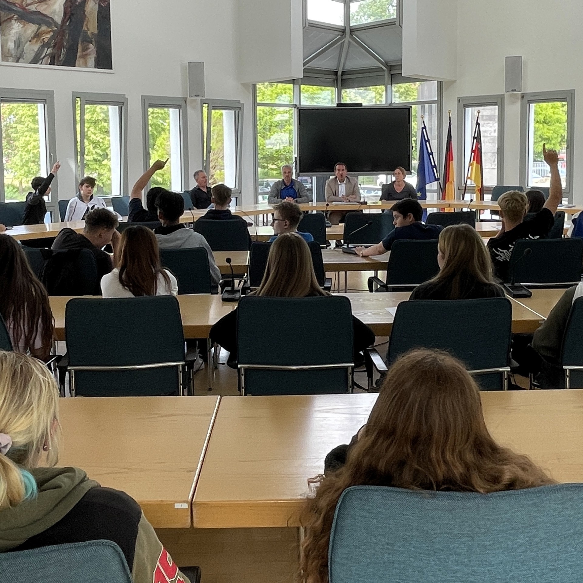 Im Ratssaal sitzen die Schülerinnen und Schüler, einige melden sich. Vorne sitzt Bürgermeister Thomas Przybylla mit Lehrkräften der Realschule plus.