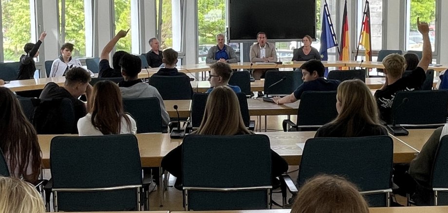 Im Ratssaal sitzen die Schülerinnen und Schüler, einige melden sich. Vorne sitzt Bürgermeister Thomas Przybylla mit Lehrkräften der Realschule plus.