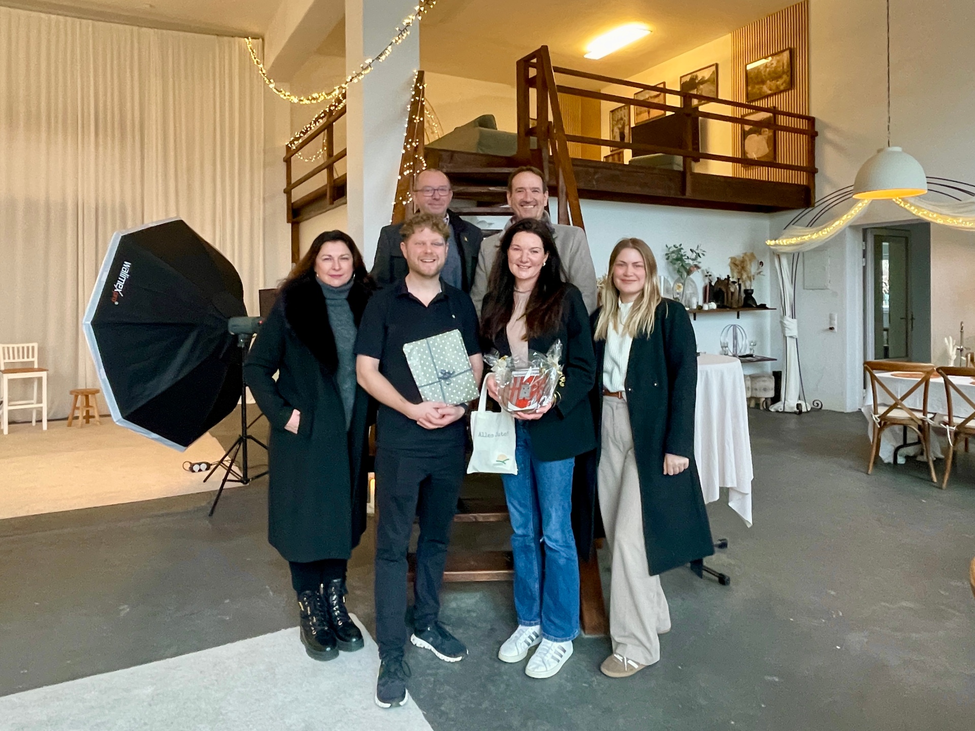 In den Räumen der neu eröffneten Agentur stehen der VG-Bürgermeister Thomas Przybylla, Stadtbürgermeister Johannes Juchem, VG-Wirtschaftsförderin Kim Lachmann, die Agentur-Gründer Nelly Ziegenbein und Simon Zimpfer mit Sängerin Ina Hauffe.