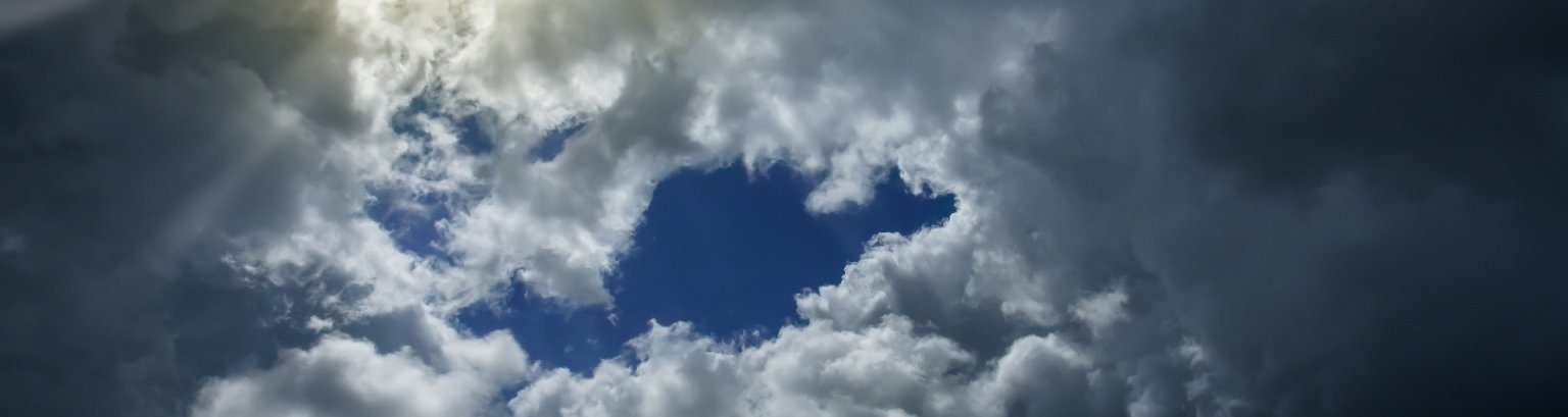 Am blauen Himmel sind Wolken wo die Sonne heraus scheint. 