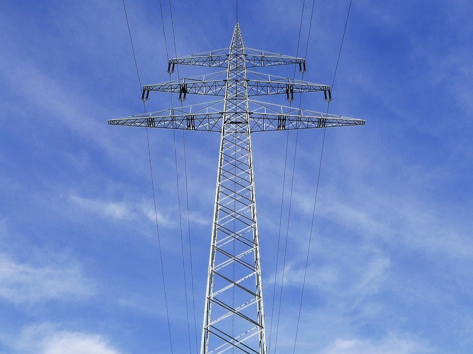 Strommast Vor einem blauen Himmel mit leichter Bewölkung ist von unten ein Strommast zu sehen.