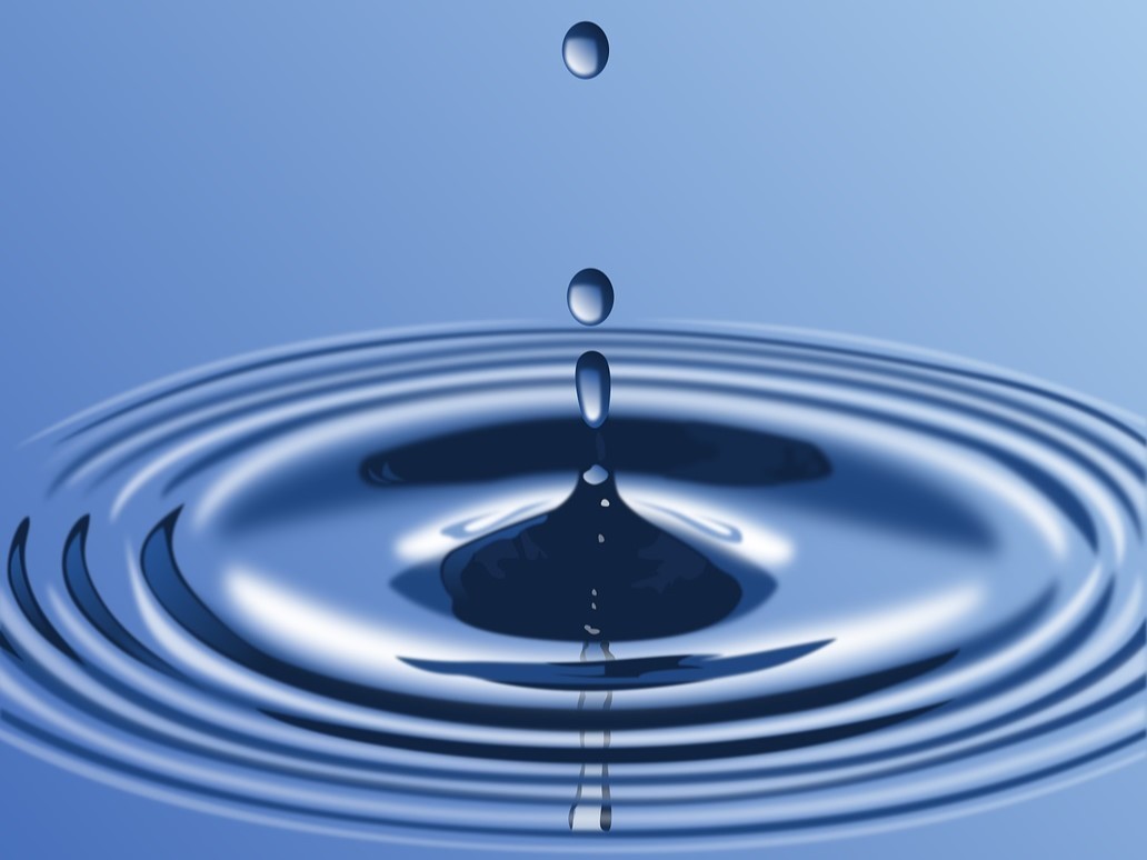 Ein Tropfen Wasser fällt auf die Oberfläche und zieht Kreise